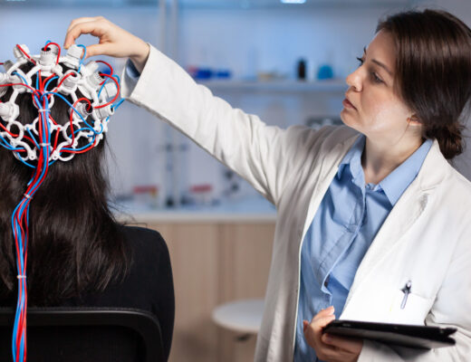 Doctor conducting a brain activity test on a patient using EEG equipment.