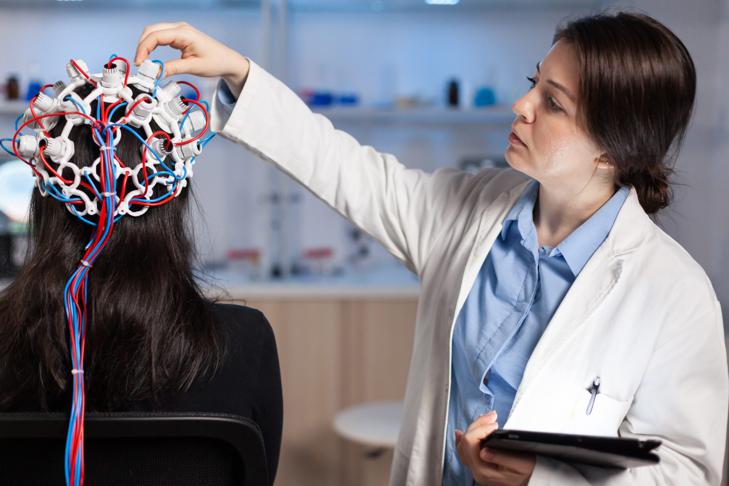 Doctor conducting a brain activity test on a patient using EEG equipment.