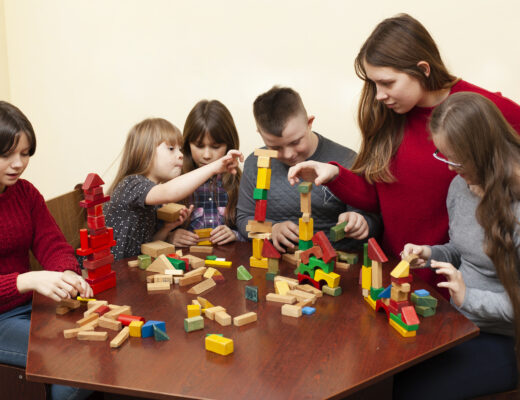 Children and teacher engaging in a collaborative block-building activity.