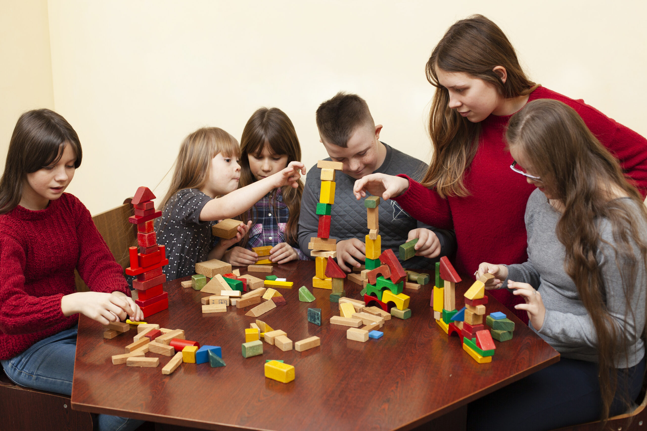 Children and teacher engaging in a collaborative block-building activity.