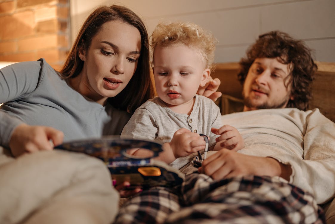 Parents reading a bedtime story to their young child