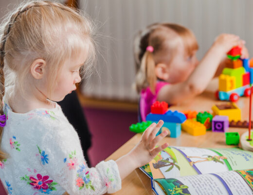 Two young children engaging in occupational therapy activities, enhancing their sensory processing skills through structured play and learning exercises.