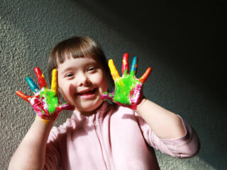kid with down syndrome playing with colors