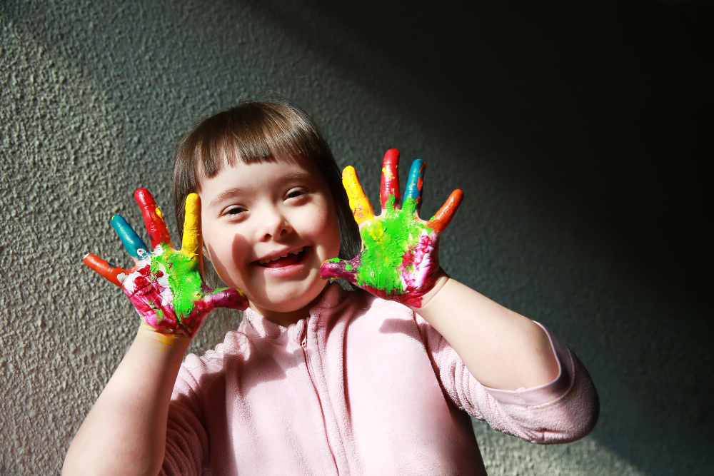 kid with down syndrome playing with colors